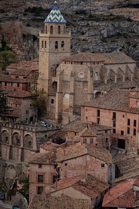 Scenic aerial view of Albarracin village with its iconic cathedral surrounded by rugged terrain in Spain.