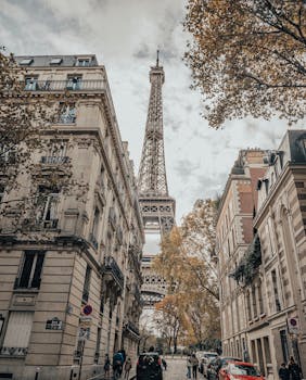 An elegant Parisian street scene with the iconic Eiffel Tower in the background during fall.